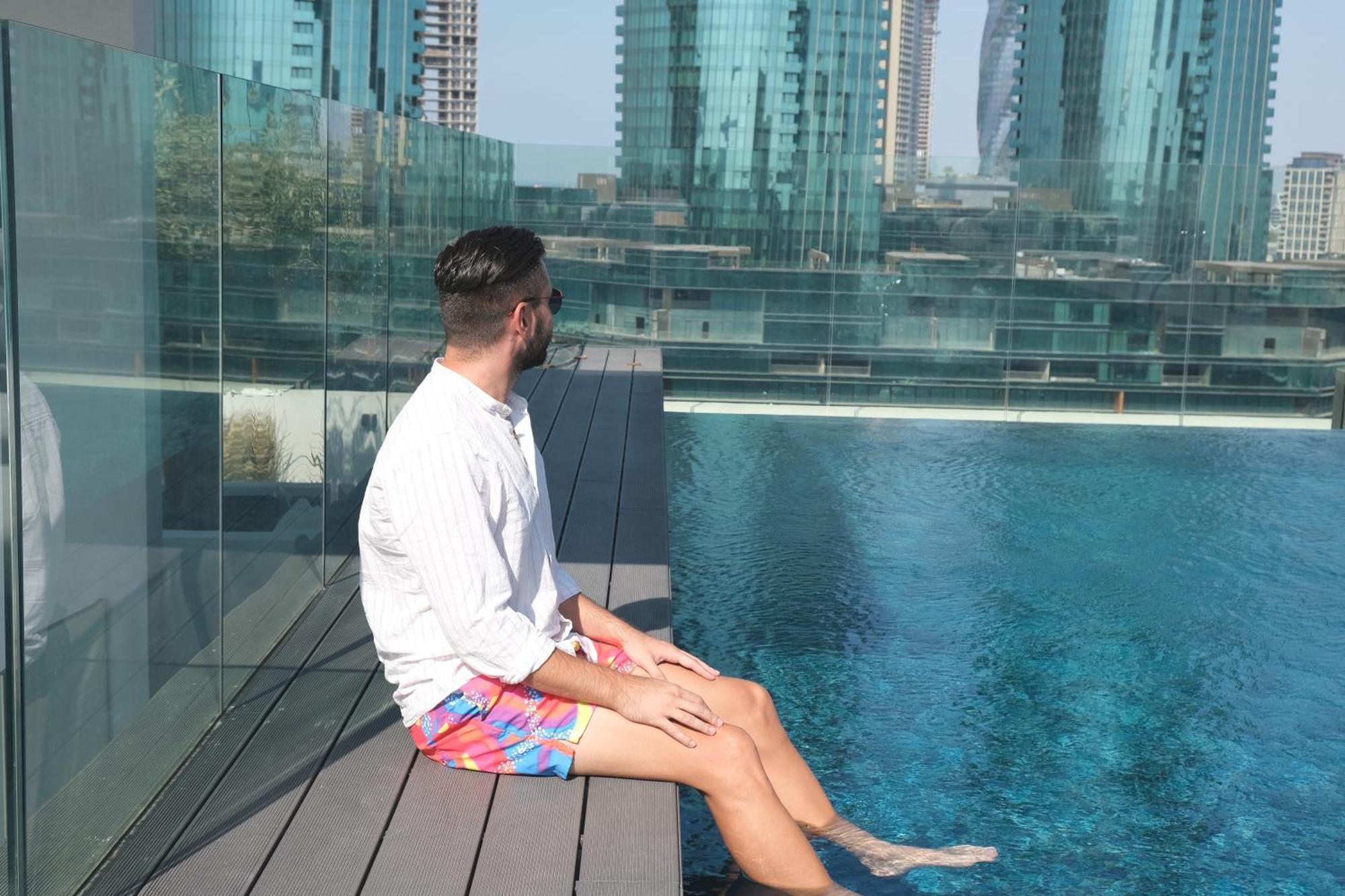 Charthouse Bahrain Hotel Manama Exterior foto A man sitting on the edge of a pool